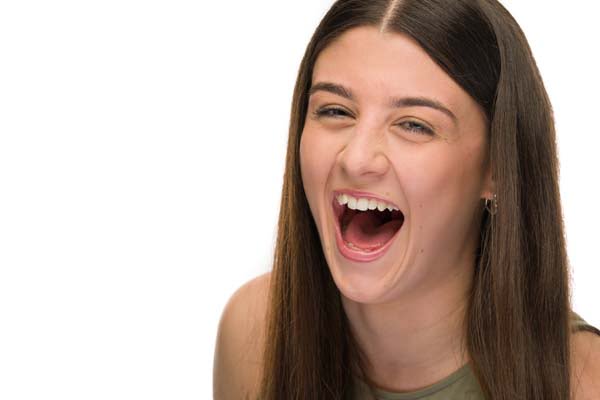 Headshot of female actress laughing on a pure white background.